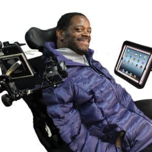 A man in a blue coat using a black iPad mounting system.