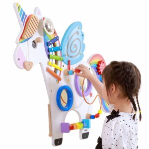 A child looking at and playing with an interactive colorful horse toy.